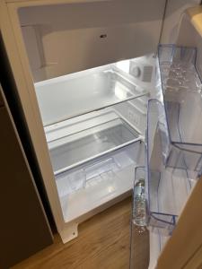 an empty refrigerator with its door open at Appartement proche Université Arras, parking gratuit et privé in Arras