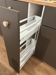 a kitchen with white drawers and a refrigerator at Appartement proche Université Arras, parking gratuit et privé in Arras