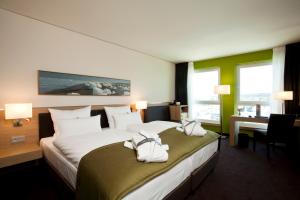 ein Hotelzimmer mit zwei Betten mit Handtüchern darauf in der Unterkunft ATLANTIC Hotel Kiel in Kiel