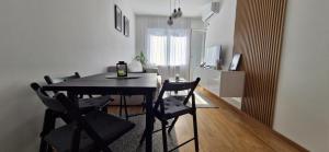 a dining room with a black table and chairs at Apartman A&V in Banja Luka