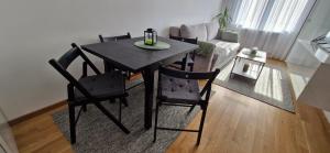 a dining room table and chairs in a living room at Apartman A&V in Banja Luka