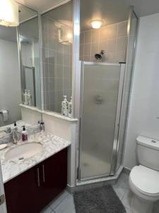 a bathroom with a shower and a sink and a toilet at Prime Location - Stunning 2-bdrm Condo in Toronto +5 photos