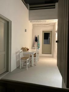 a white dining room with a white table and chairs at Marpissa - Traditional House in Márpissa +14 photos