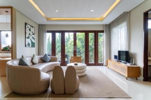 a living room with a couch and a tv at Breeze Blows City View Villa 4 Bedrooms and 1 Familly Bedroom With a Private Heated Swimming Pool and a Billiard Table in Bandung