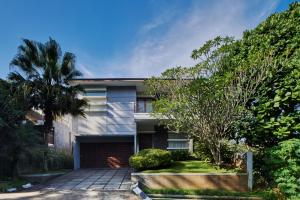 a house with a garage and a palm tree at Breeze Blows City View Villa 4 Bedrooms and 1 Familly Bedroom With a Private Heated Swimming Pool and a Billiard Table in Bandung