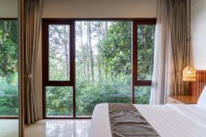 a bedroom with a bed and a large window at Breeze Blows City View Villa 4 Bedrooms and 1 Familly Bedroom With a Private Heated Swimming Pool and a Billiard Table in Bandung +45 photos