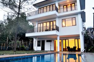 a house with a swimming pool in front of it at Breeze Blows City View Villa 4 Bedrooms and 1 Familly Bedroom With a Private Heated Swimming Pool and a Billiard Table in Bandung
