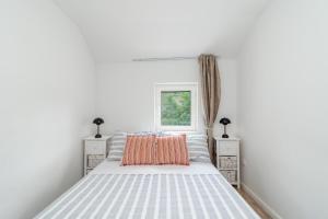 a white bedroom with a large bed with orange pillows at Balatura House in Trogir