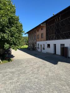 a large brick building with a tree next to it at falternhof apartment - geschichte trifft auf design in Höslwang