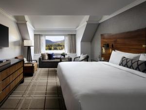 a hotel room with a large bed and a living room at Fairmont Chateau Whistler in Whistler