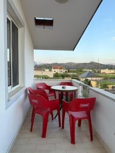 a balcony with red chairs and a table and a window at Daydream Villas in Shkodër +33 photos