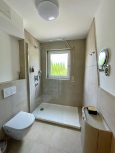 a bathroom with a shower and a toilet and a window at LEO Apartments in Leonberg