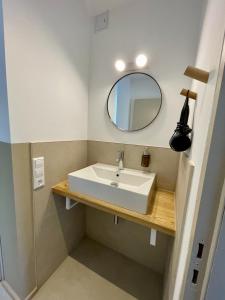 a bathroom with a white sink and a mirror at LEO Apartments in Leonberg