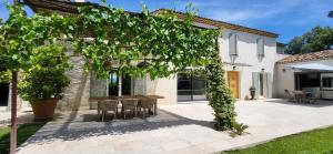 a patio with a table and chairs in front of a house at La Cigale dans l'Olivier in Vernègues