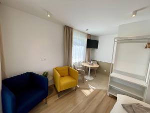 a living room with a yellow chair and a table at LEO Apartments in Leonberg +13 photos
