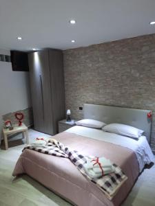a bedroom with a large bed and a brick wall at Casa vacanza il pescatore in Castel di Sangro