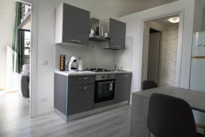 a kitchen with a stove and a table in it at Malpensa Elegant Loft in Gallarate