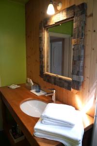 a bathroom with a sink with a mirror and towels at Golf und Berglodge Velden am Wörthersee in Köstenberg +28 photos