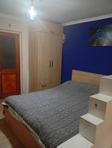 a bedroom with a bed and a blue wall at Nika's Home in Ureki