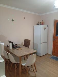 a dining room with a table and a white refrigerator at Nika's Home in Ureki