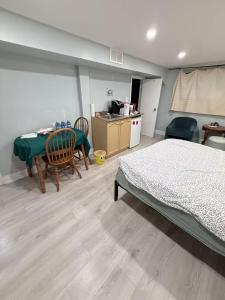 a bedroom with a bed and a table and chairs at Ideal Bachelor Suite For Couples in Aurora in Aurora