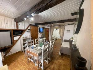 a dining room with a table and chairs and a tv at Studio de charme in Breil-sur-Roya