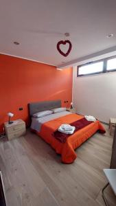 a bedroom with a bed with orange walls and a heartendant at Casa vacanza il pescatore in Castel di Sangro