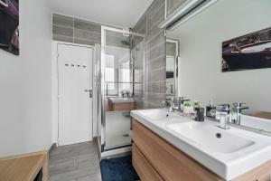 a bathroom with a white sink and a mirror at Pop Eurexpo - Parking Privé, Terrasse, Climatisation in Bron