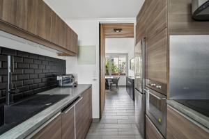 a kitchen with wooden cabinets and a counter top at Pop Eurexpo - Parking Privé, Terrasse, Climatisation in Bron +5 photos