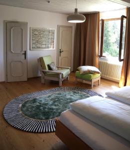 a bedroom with a bed and a chair and a rug at Golf und Berglodge Velden am Wörthersee in Köstenberg
