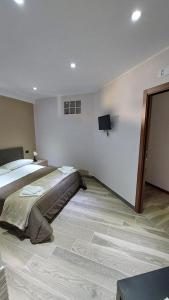 a bedroom with a bed and a tv on the wall at Casa vacanza il pescatore in Castel di Sangro
