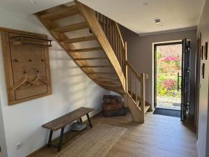 ein Flur mit einer Holztreppe und einer Bank in der Unterkunft Am Scheunengarten in Klausdorf Brandenburg
