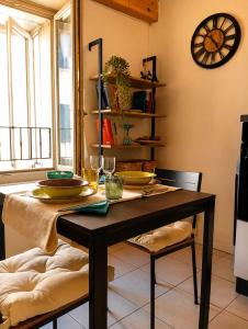 a dining room table with two chairs and a clock at Casa Giorgia Collio Suite in Cormòns