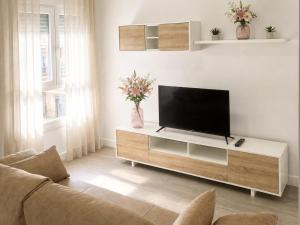 a living room with a flat screen tv on a entertainment center at Hospedium GL Linarejos Suites Parking Gratis in Linares