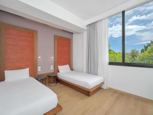 a bedroom with two beds and a window at B&B HOTEL Padova Methis in Padova