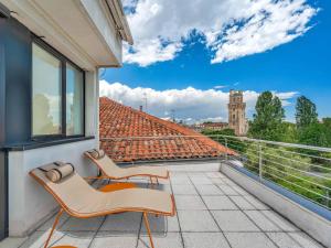 a balcony with two chairs and a view of a building at B&B HOTEL Padova Methis in Padova