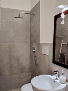 a bathroom with a sink and a toilet and a mirror at Bianco e Rosmarino in Selva di Fasano +24 photos