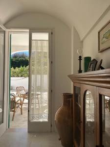 a living room with a glass door and a vase at Bianco e Rosmarino in Selva di Fasano