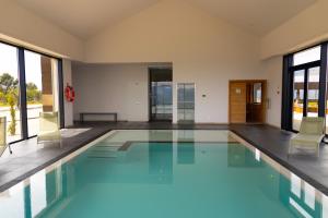 a swimming pool with two chairs in a building at Hotel Mezio National Park in Soajo