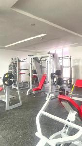 a gym with lots of machines and red chairs at Habor Hotel & Suites- Abuja in Abuja