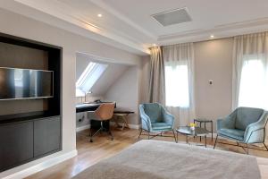 a hotel room with a bed and a desk and chairs at Cantilly Garden in Samobor