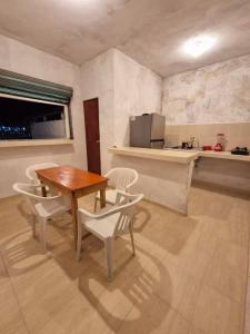 a dining room with a table and chairs and a kitchen at Casa Mayan in La Vigueta