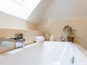 a bath tub in a bathroom with a skylight at Golden Villa Kraków - Stylowa Willa z Ogrodem i Grillem in Węgrzce +59 photos