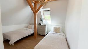 two twin beds in a room with a window at Golden Villa Kraków - Stylowa Willa z Ogrodem i Grillem in Węgrzce