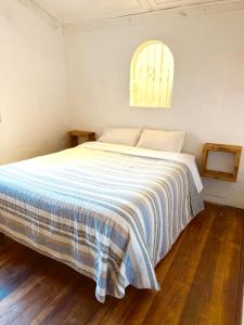 a bedroom with a bed with a blue and white blanket at Ola in Puchuncaví