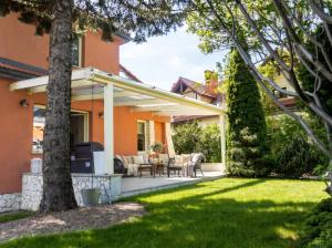 a patio with chairs and tables in a yard at Golden Villa Kraków - Stylowa Willa z Ogrodem i Grillem in Węgrzce