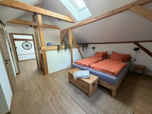 ein Schlafzimmer mit einem Bett mit orangefarbenen Kissen auf dem Dachboden in der Unterkunft Am Scheunengarten in Klausdorf Brandenburg + 3 Fotos