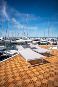two beds on a dock with boats in a marina at House Boat Cervia in Cervia