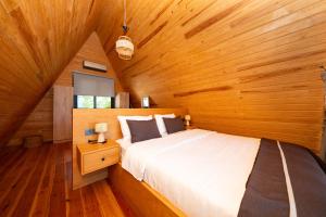 a bedroom with a bed in a wooden cabin at Begonvil Gümüşlük in Gümüşlük