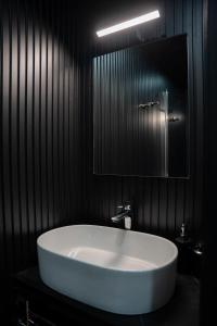 a white sink in a black bathroom with a mirror at House Boat Cervia in Cervia +11 photos